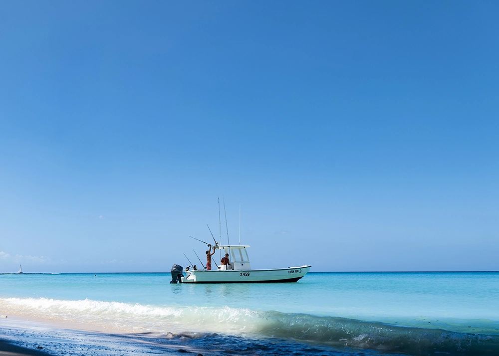 Clear blue water and a small boat off Barbados’ west coast